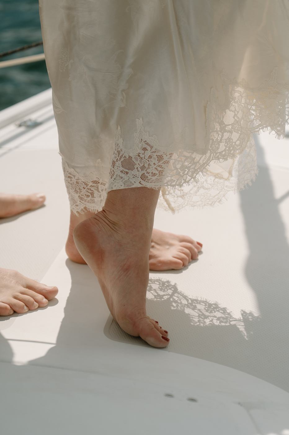 Barefoot on the deck, lace hem of Lauren's dress